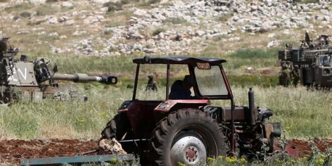 Agricultor palestino de Aqraba, al sur de Nablus, en Cisjordania, junto a los tanques de soldados israelíes. (Jaafar Ashtiyeh/AFP/Getty Images)
