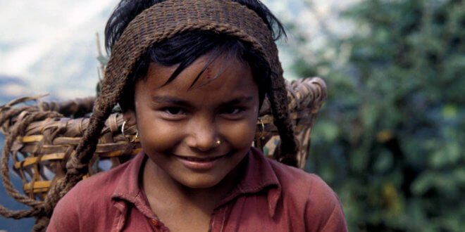 Una niña nepalí transporta productos agrícolas a lo largo de un camino montañoso de 65 km. Foto: FAO/Franco Mattioli