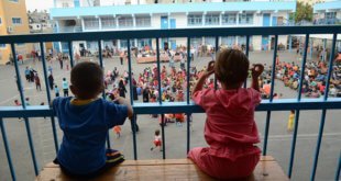 Dos niños se asoman a los balcones del centro colectivo Bahrain en Gaza, donde siguen albergados desde que sus casas fueran destruidas en 2014. Foto: UNRWA / Fadi Thabet