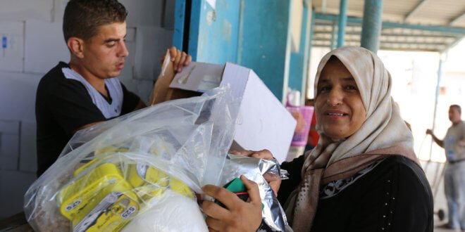 UNRWA / Tamer Hamam Una refugiada palestina recibe ayuda de la UNRWA en un centro de Gaza