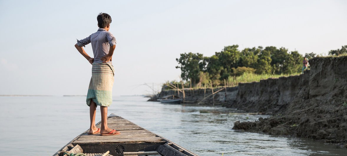 OIM/Amanda Nero Un niño observa la orilla desde un barco cerca de Sirajganj, una comunidad afectada por la grave sequía que ha dejado a muchos desplazados. Sirajganj, Bangladesh