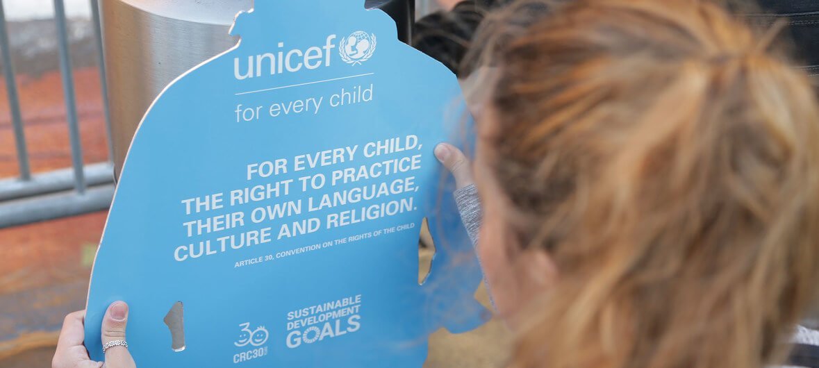 UNICEF Una niña obervando un muñeco de cartón en forma de chico que forma parte de la instalación de UNICEF sobre la Convención sobre los Derechos del Niño, expuesta fuera de la Sede de las Naciones Unidas.